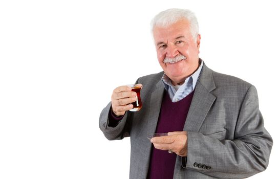Half Body Shot of a Senior Businessman Holding a Glass of Turkish Tea and Smiling at the Camera Against White Background.