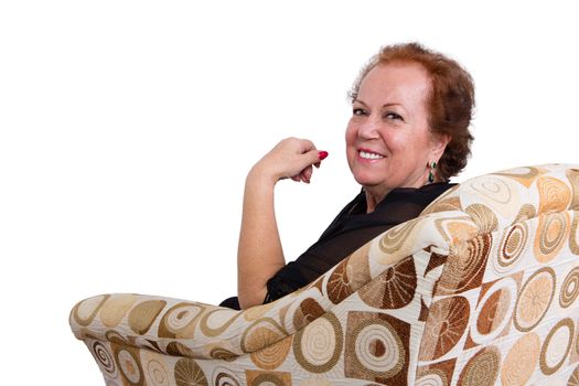 Happy Senior Woman Sitting on a Couch, Smiling at the Camera from her Behind, Isolated on White Background.