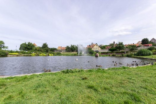 Pond in Almedalen, Visby, Sweden with birds and cloudy sky.