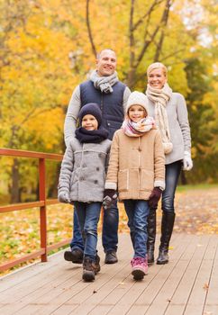 family, childhood, season and people concept - happy family in autumn park