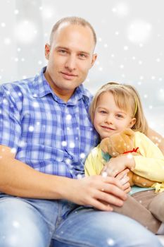 family, child and happiness concept - smiling father and daughter with teddy bear toy at home