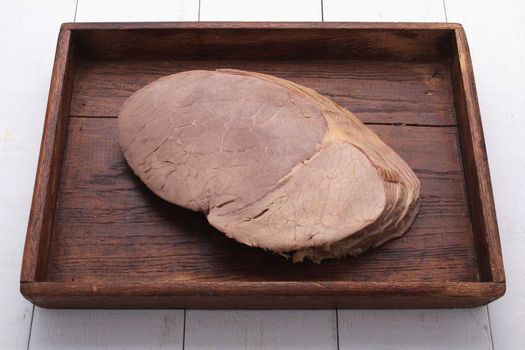 sliced roast beef on wooden platter