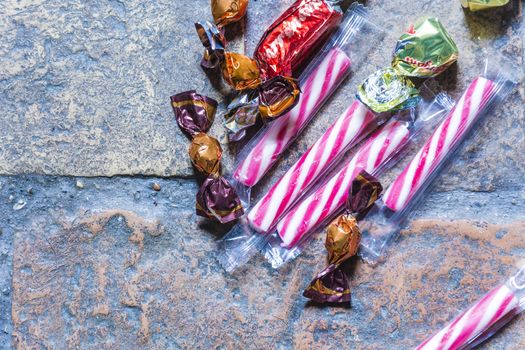 mixed candies on a rough bricked floor