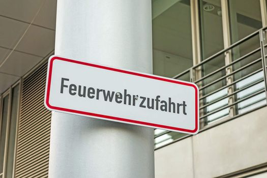 Sign labeled with Feuerwehrzufahrt (fire rescue path) on a pillar in city