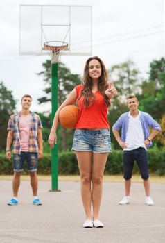 summer vacation, holidays, games, gesture and people concept - group of smiling teenagers playing basketball and showing thumbs up outdoors