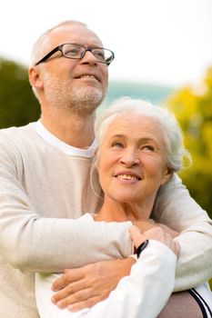 family, age, tourism, travel and people concept - senior couple hugging in park