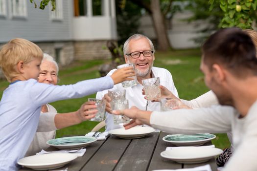 family, happiness, generation, home and people concept - happy family having holiday dinner outdoors