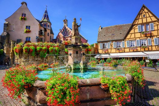 Half-timbered medieval houses decorated with flowers in Eguisheim village along the wine route in Alsace, France