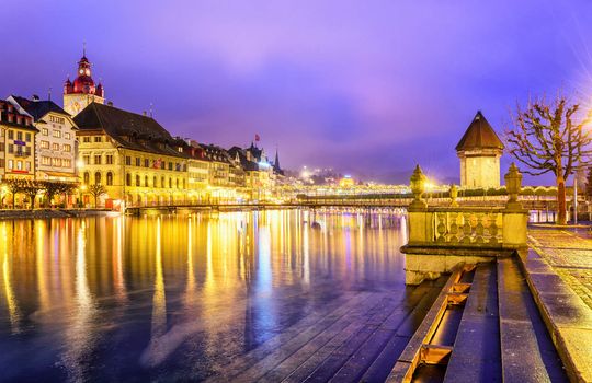 Lucerne, Switzerland. View over Reuss river to the old town and Water tower in the evening.