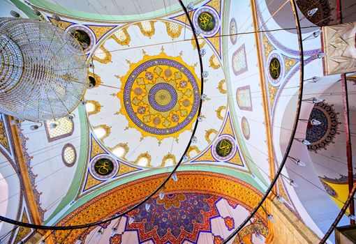 Chandelier and colorful decorated ceiling in the interior of a turkish mosque