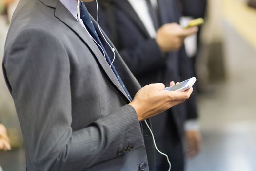 Businessmen using their cell phones on Tokyo subway. Horizontal composition.
