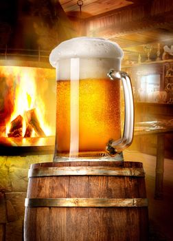 Mug of beer on wooden cask near fireplace in pub