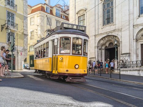 Lisbon, Portugal - August 4, 2015: Yellow tram riding through the city streets of Lisbon, Portugal.