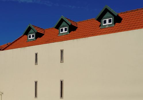 A house with red tile roof and three garrets