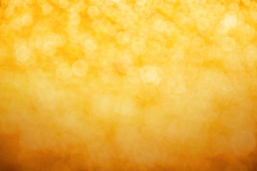 Golden glitter bright magic light circles christmas abstract blur effect background with darker bottom part