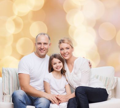 family, childhood, holidays and people concept - smiling mother, father and little girl over beige lights background