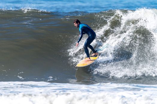 Surfer in action on the ocean waves on a sunny day.