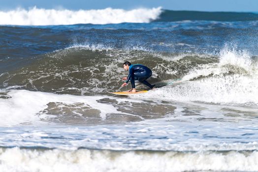 Surfer in action on the ocean waves on a sunny day.