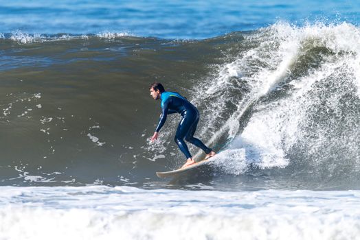 Surfer in action on the ocean waves on a sunny day.