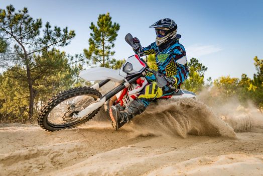 Enduro bike rider on action. Turn on sand terrain.