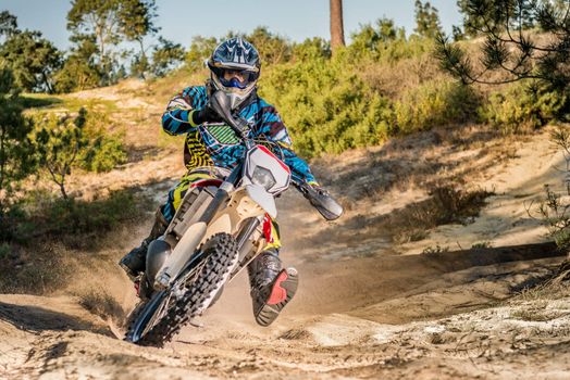 Enduro bike rider on action. Turn on sand terrain.