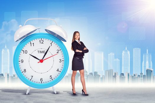 Buisnesswoman with big alarm clock on city background