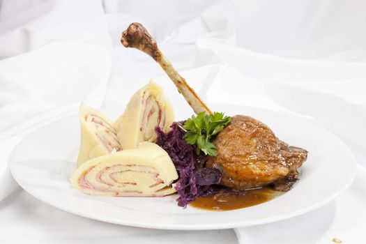 Baked duck leg with potato ham rolls and red cabbage