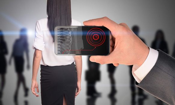 Businessman holding smartphone with x-ray of woman