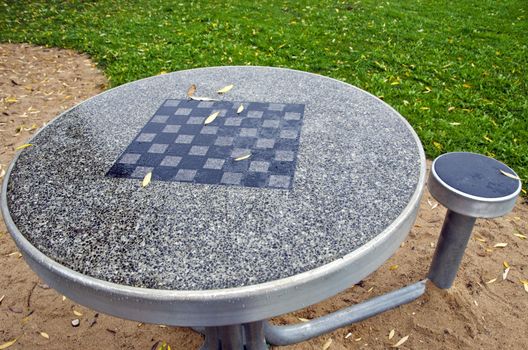 Table with chess board and chairs in the city park