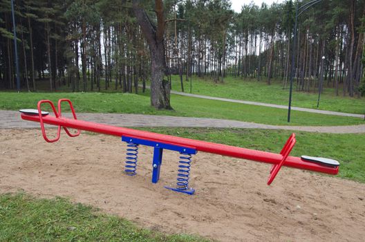 Red and blue metal children seesaw in the park   