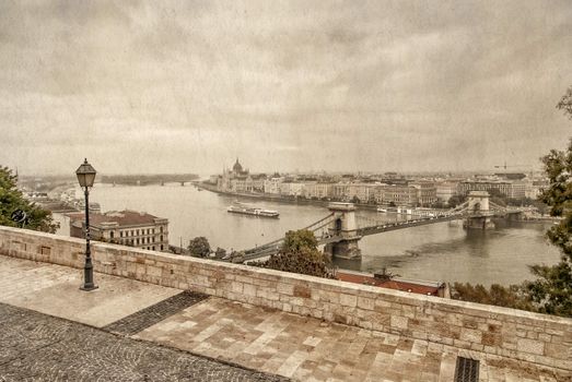 View over Danube river in Budapest with parliament building and szechenyi bridge behind taken from buda castle complex. Photo in old color image style.