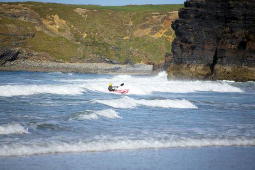 bright winter view of kayaker at ballybunion beach and cliffs on the wild atlantic way in ireland