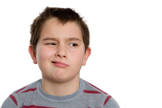 Close up Ten Year Old Boy Looking to the Right with Bored Facial Expression, Isolated on White Background.