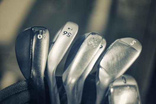 Macro detail of golf irons, sand and loft wedges or irons - sepia toned