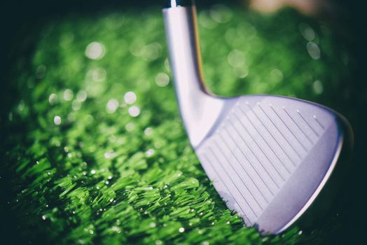 Golf club head open face iron detail against turf