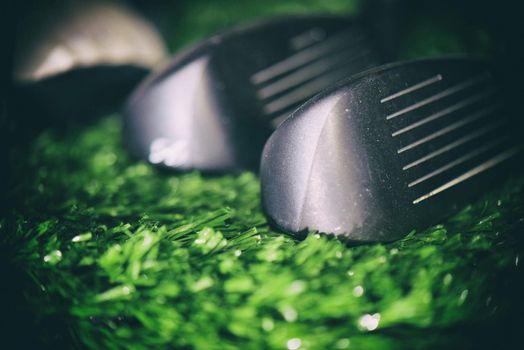 Macro detail of golf club face irons against turf