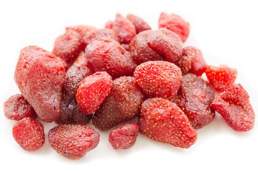 Pile of tasty red dried dehydrated strawberries on white background.