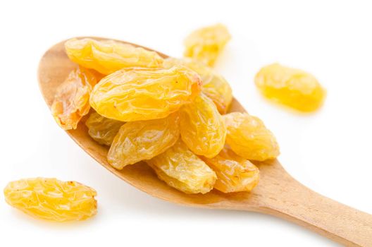 Yellow or gold raisins in wooden spoon on white background.