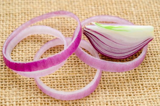 Sliced red onion on sack background.