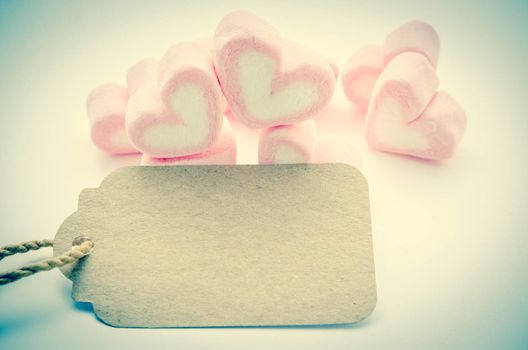 Pink Marshmallow heart shape with blank paper tag for your text in vintage style. Love concept.