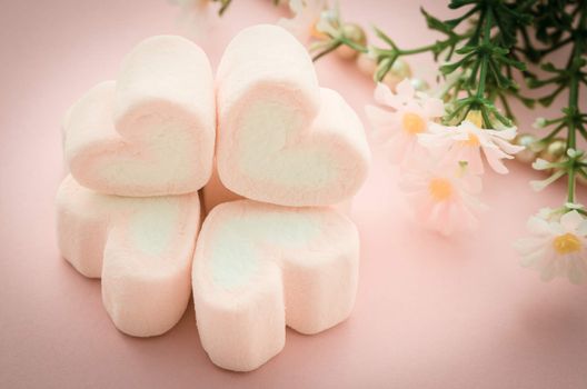 sweet heart shape of pink marshmallows with flower on tablecloth background,decoration for love and valentine day concept.