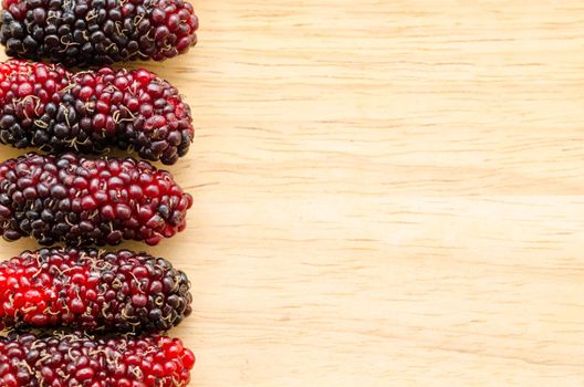 fresh organic mulberry wooden background.