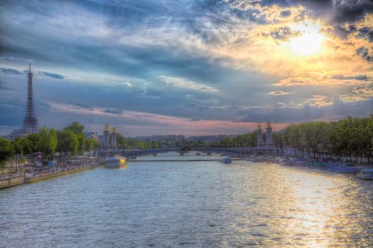 Sun coming down over Seine river in Paris with Eiffel Tower in the background