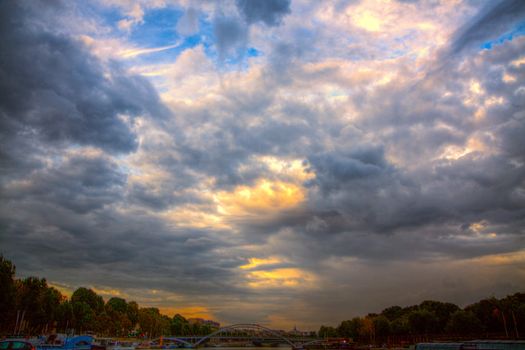 Dramatic stormy clouds forming over Seine river in Paris on summer evening