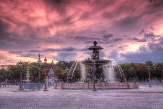 Historical sculptures on famous square La Concorde in Paris with burning skies in late evening