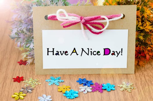 Have a nice day paper card on wooden background.