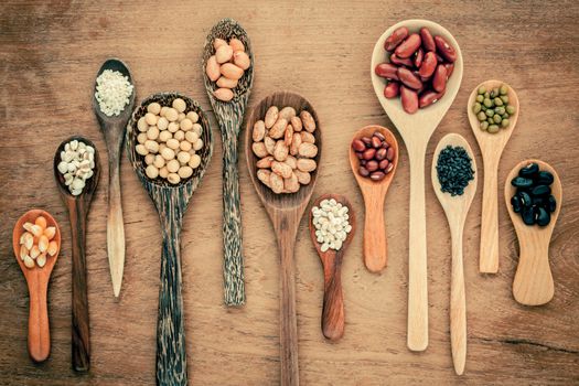 Assortment of beans and lentils in wooden spoon on teak wood background. mung bean, groundnut, soybean, red kidney bean , black bean ,sesame, corn ,red bean and brown pinto beans .