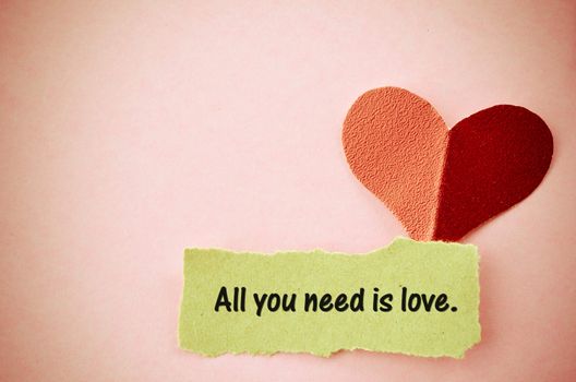All you need is love word on paper torn and paper heart shape in vintage style.