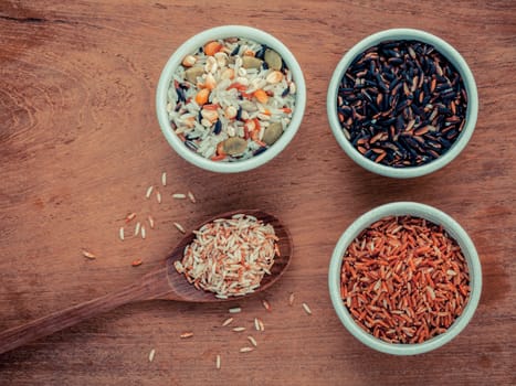 Mixed Whole grain Traditional Thai rice in the spoon and bowl best rice for healthy and clean food on teak wood background.