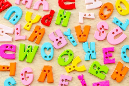 Colorful of plastic alphabet on wooden background